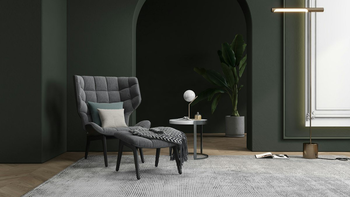 Coin lecture au mur vert profond avec arche peinte et fauteuil gris